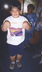The photograph shows two students dramatizing dinosaurs.